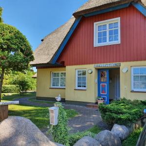 博恩"Kombüse" by Ferienhaus Strandgut的红色和黄色的房子,有红色屋顶