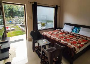 兰纳加Anugraha Homestay的一间卧室设有一张床、一个窗口和一把椅子