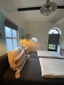 坎珀兰Het Koetshuis的客房设有两张床和窗户。