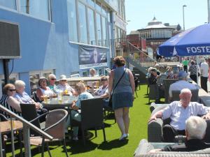 布莱克浦皇家海岸酒店的一群坐在草地上桌子的人