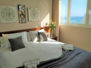 贝纳尔马德纳New 2023 Don Gustavo, Beach Front, Sea Views的卧室配有带枕头的白色床和窗户。