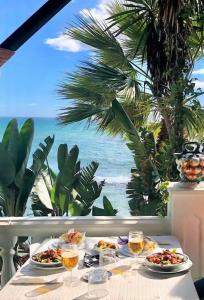 贝纳尔马德纳New 2023 Don Gustavo, Beach Front, Sea Views的一张桌子,上面放着两盘食物和酒杯