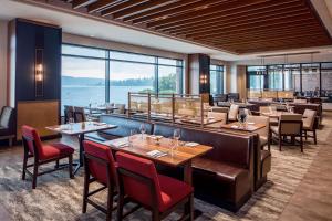 伦顿西雅图南港华盛顿湖凯悦酒店的餐厅设有桌椅和大窗户。