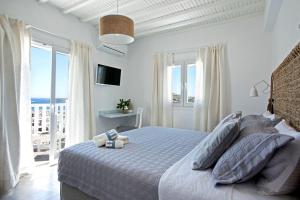 米克诺斯城Amperian Mykonos Suites & Villas的一间卧室设有一张床,享有海景