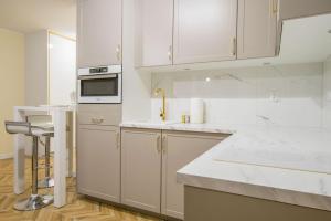 戈莱纽夫Central Apartments Goleniow Luxury的白色的厨房配有白色橱柜和水槽