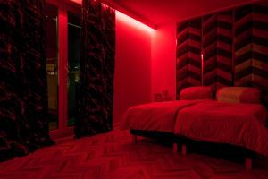 戈莱纽夫Central Apartments Goleniow Luxury的红色卧室设有一张床和红灯