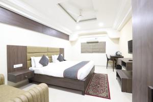 艾哈迈达巴德Alba Premier, Ahmedabad的配有一张床和一张书桌的酒店客房