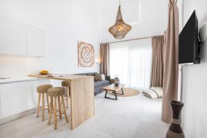 卡尔帕索斯Alkithea luxury suites的厨房以及带桌椅的起居室。