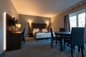 莫吕Thon Partner Hotel Måløy的酒店客房带一张床、一张桌子和椅子