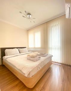 普罗夫迪夫Etica Apartments的一间卧室配有一张带白色床单和天花板的床。