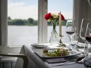 汉堡左伦斯比克尔法豪斯酒店的一张桌子,上面放着一盘食物和酒杯