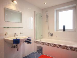 胡本Apartment Aktiv by Interhome的一间带水槽和浴缸的浴室以及窗户。