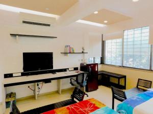孟买Apartment In Mumbai City Centre的客厅配有书桌和电视。