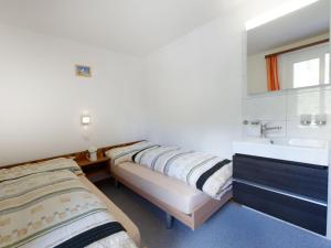 采尔马特Apartment Hubertus-2 by Interhome的一间带两张床、一个水槽和浴缸的浴室