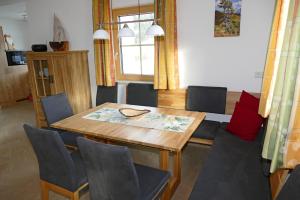 WeisspriachFerienhaus Weißpriach的一间带木桌和椅子的用餐室