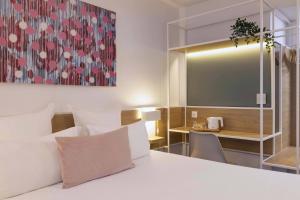 巴黎巴黎路易·勃朗站酒店的酒店客房配有一张床铺和一张桌子。