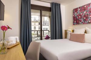 巴黎巴黎路易·勃朗站酒店的配有一张床、一张书桌和一扇窗户的酒店客房