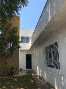 因比图巴Residêncial Casa da Vila apto 1的白色的建筑,在建筑的一侧有一个门