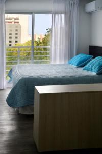 蒙得维的亚Quijano Hotel - Aparts & Suites的一间卧室设有一张床和一个大窗户