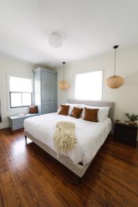 查尔斯顿Guesthouse Charleston EAST 46 F的卧室设有一张白色大床和两个窗户。
