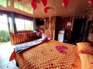 迦太基Cabañas Cerro Verde Lodge y Spa的一间卧室配有一张大床,里面装有红色气球