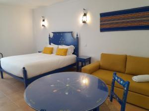 雷根古什-迪蒙萨拉什Casas da Minh'Alma的客房设有床、沙发和桌子。