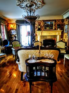魁北克市奥堡莫伊森旅馆的客厅设有壁炉和带酒杯的桌子