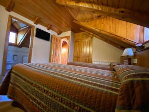 CardetCasa Torellola的一间卧室设有一张大床和木制天花板。