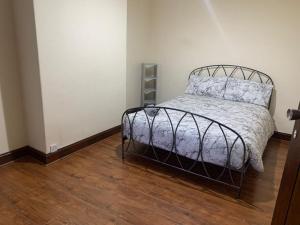 曼彻斯特3/4 Bedroom House的一间卧室配有一张床,铺有木地板