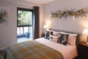 格拉斯哥Riverside West End Apartment的卧室配有带枕头的床铺和窗户。