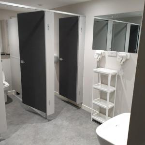 爱丁堡JUST SLEEP Hostel的浴室设有两个黑色的摊位和一个水槽