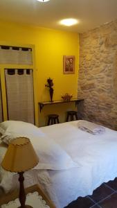 Fuentes de OñoroEl Condado Casa Rural的卧室配有白色的床和石墙