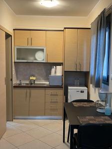 马科普隆AVR Airport Deluxe Suites 4的厨房配有木制橱柜、桌子和微波炉