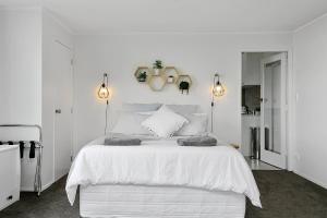 陶波Acacia Bay的白色卧室配有一张带两个灯的白色大床