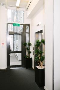 惠灵顿吉尔默公寓式酒店的带有盆栽植物的办公室的出口标志