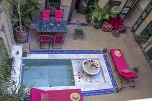 马拉喀什Riad Dar Habiba by Garden Wonders的享有带桌椅的游泳池的顶部景致