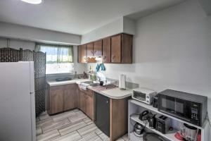 金曼Kingman Apartment Less Than 2 Miles to Route 66 Sign!的厨房配有木制橱柜和白色冰箱。