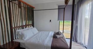 KumbatangEagle Bay Retreat Borneo Beach Villas Beach Front的一间卧室设有天蓬床和窗户。