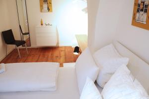 雷根斯堡Wassergasse 11的客房内的白色床和白色枕头