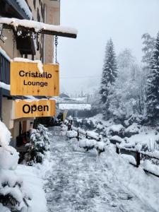 阿兰尼亚·瓦尔塞西娅Hotel Cristallo的一条有雪覆盖的街道,上面有读书的标牌