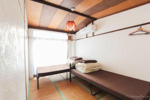 名古屋Otohaya Guesthouse的小房间设有长凳和窗户