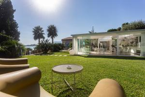 冯塔尼比安奇Calapetra Resort的房屋设有草坪,配有桌椅