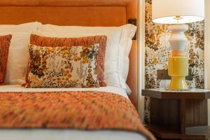 里斯本Palácio Ludovice Wine Experience Hotel的一张带枕头的床和一张桌子上的台灯