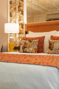 里斯本Palácio Ludovice Wine Experience Hotel的一间卧室配有带枕头和台灯的床