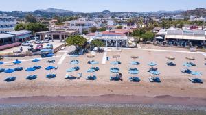 法里拉基cactus suites的享有海滩的空中景致,配有椅子和遮阳伞