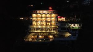 达兰萨拉Asia Health Resorts & Spa的一座晚上有灯的建筑