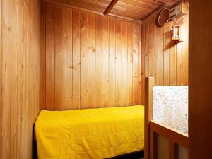 旭川A-GATE HOTEL 旭川 -Asahikawa-的卧室配有一张黄色的床,位于木墙内