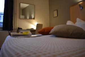 法尔肯堡亚特兰大酒店的卧室配有一张带镜子的白色床