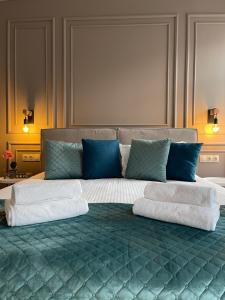 利沃夫Von Cruss apartments in Lviv的一张配有白色床单和蓝色枕头的大床