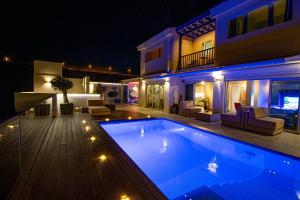 马斯帕洛马斯Luxury Villa Morelli with seaview & heated pool的一座晚上设有游泳池的房子